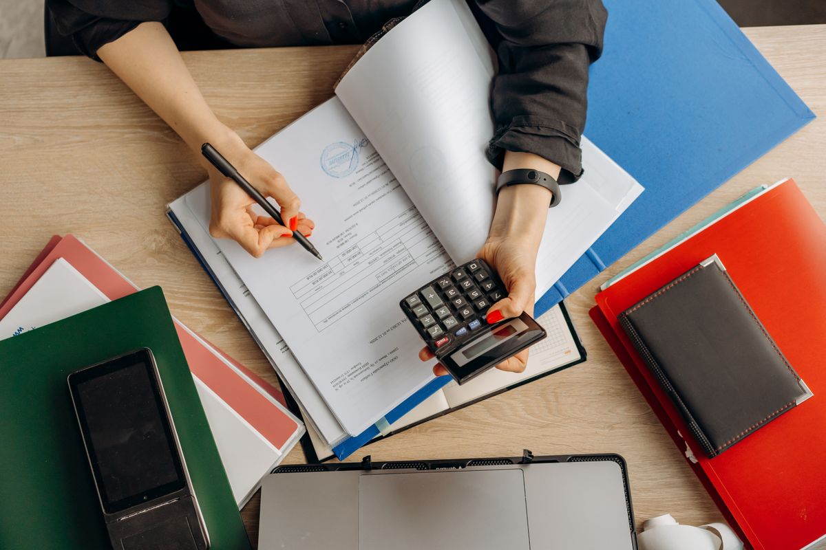Accountant reviewing financial documents with a calculator at an organized desk